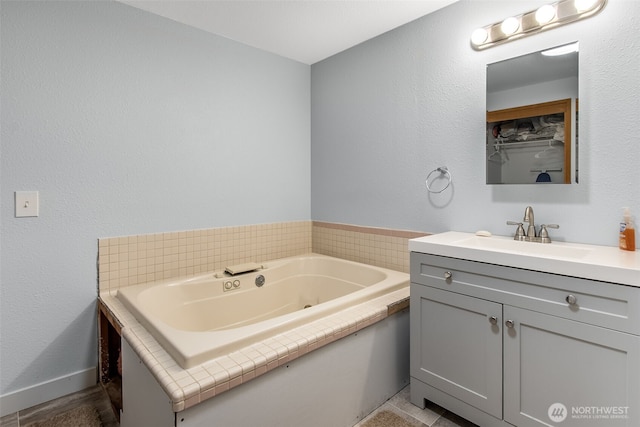 full bath with vanity and a whirlpool tub