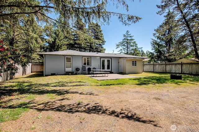 rear view of house with a patio area, a fenced backyard, and a yard