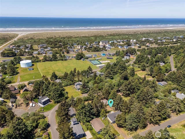 drone / aerial view featuring a residential view, a water view, and a beach view