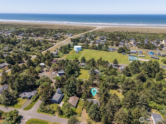 birds eye view of property with a water view and a view of the beach