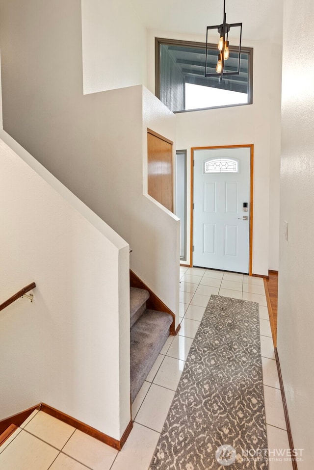 tiled entrance foyer featuring stairway and baseboards