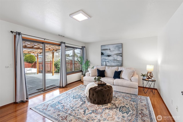 living room featuring visible vents and wood finished floors