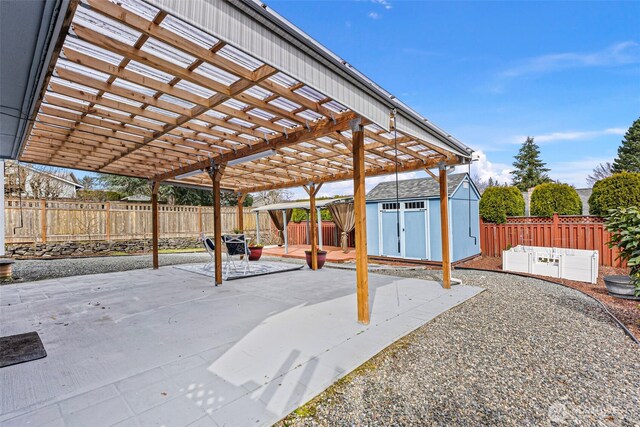 view of patio featuring a storage shed, a fenced backyard, a pergola, and an outdoor structure