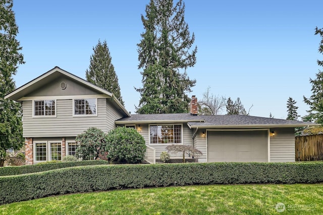 tri-level home featuring a chimney, an attached garage, and fence