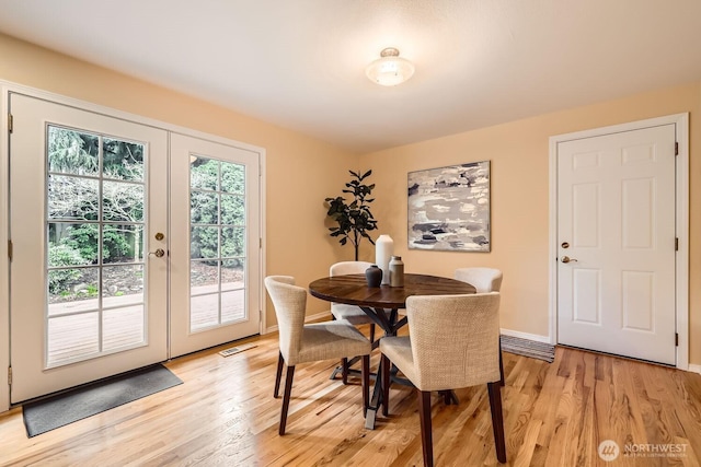 dining area featuring baseboards, french doors, visible vents, and light wood-style floors