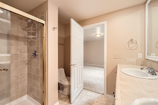 bathroom with baseboards, a shower stall, toilet, and vanity