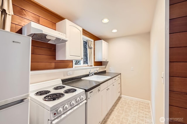 kitchen featuring under cabinet range hood, white appliances, a sink, white cabinets, and dark countertops