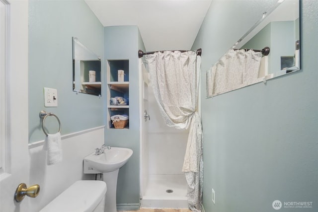 full bath featuring a stall shower and toilet