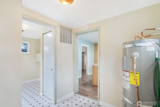 utility room with visible vents and electric water heater