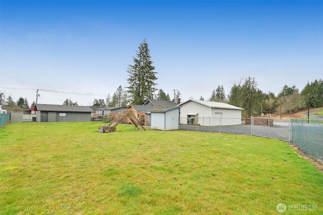 view of yard with a fenced backyard, an outdoor structure, and a storage unit