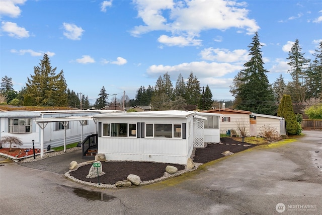 manufactured / mobile home with a sunroom and driveway