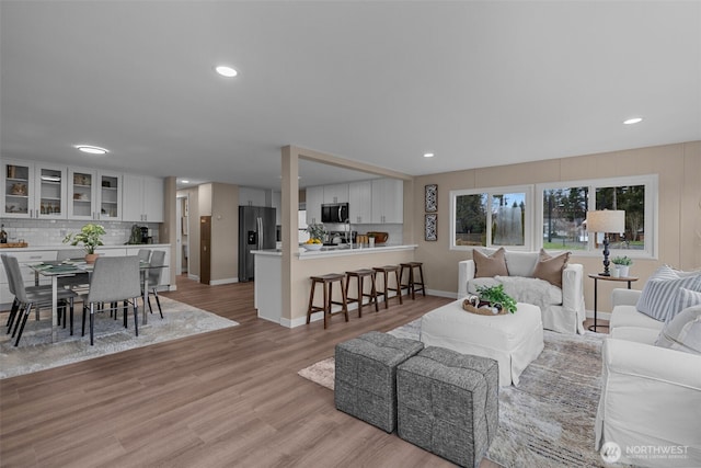 living room featuring recessed lighting, light wood-type flooring, and baseboards