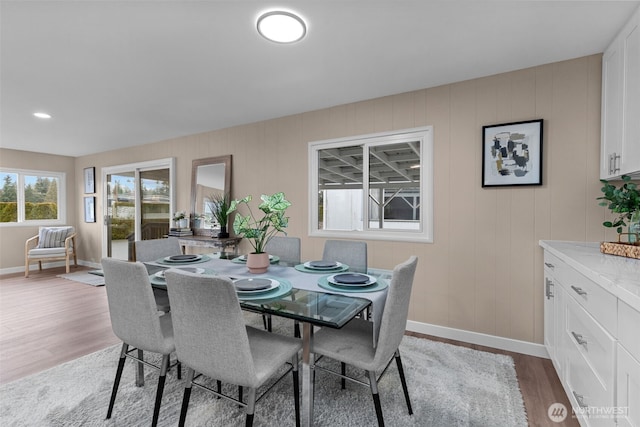 dining area with baseboards and light wood finished floors