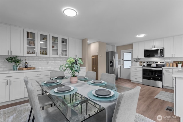 dining area featuring visible vents and light wood-style flooring