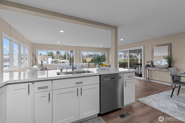 kitchen with a sink, visible vents, white cabinets, light countertops, and stainless steel dishwasher