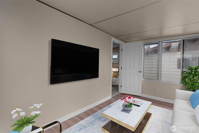 living area featuring baseboards and wood finished floors
