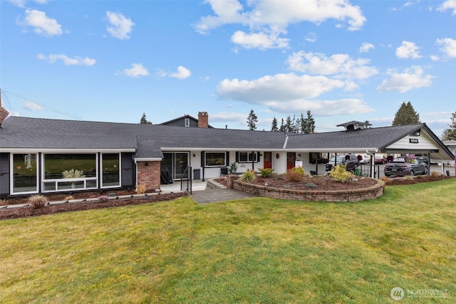 single story home featuring a shingled roof, brick siding, a chimney, and a front lawn