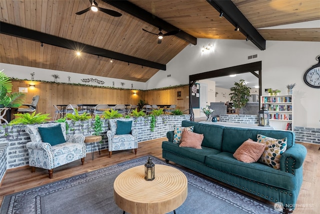 living room with lofted ceiling with beams, wood ceiling, track lighting, and wood finished floors