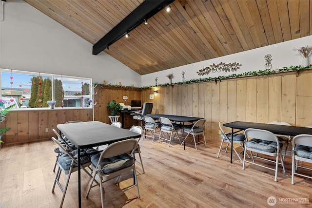 dining space featuring light wood-type flooring, rail lighting, wood ceiling, and beam ceiling