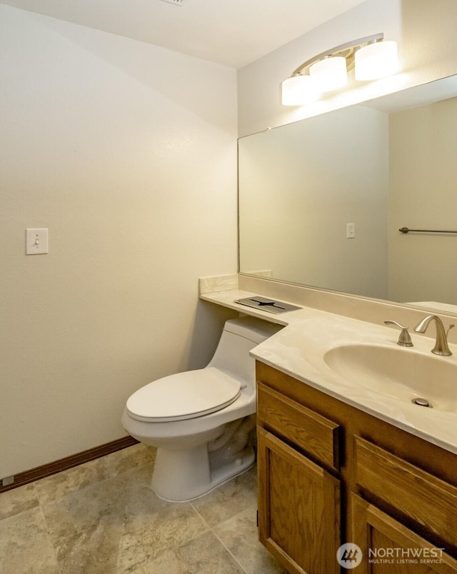 half bathroom with toilet, baseboards, and vanity