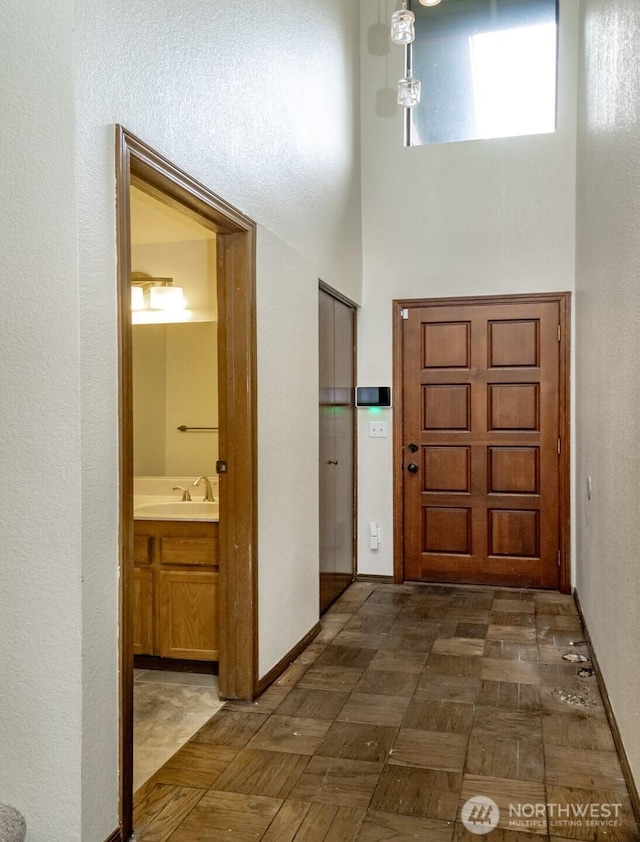 entrance foyer featuring a towering ceiling and baseboards