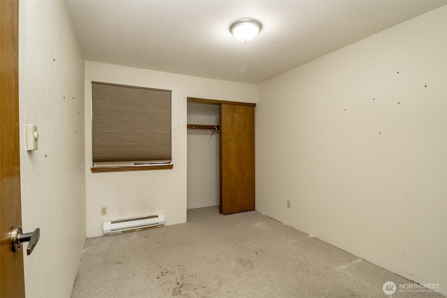 unfurnished bedroom with a baseboard heating unit, a closet, and light colored carpet