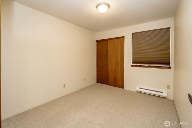 carpeted empty room with a baseboard radiator