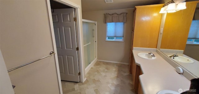 full bath with a shower stall, vanity, and baseboards