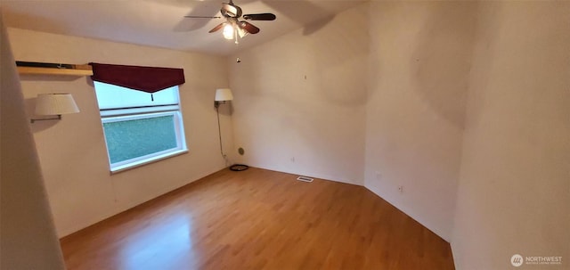 unfurnished room featuring visible vents, a ceiling fan, and wood finished floors