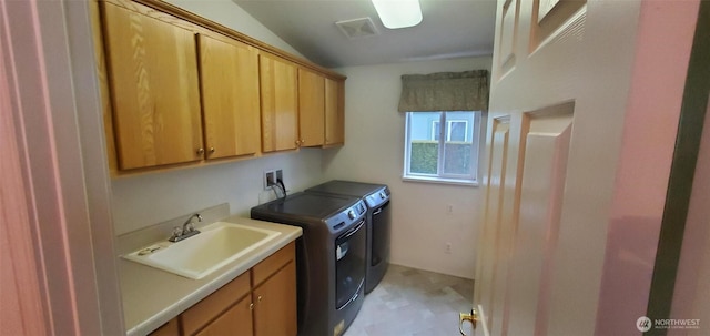 washroom featuring visible vents, cabinet space, a sink, and washer and clothes dryer