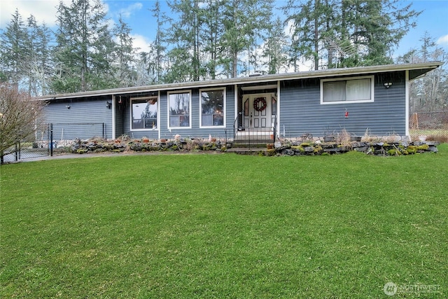 ranch-style house with fence and a front lawn