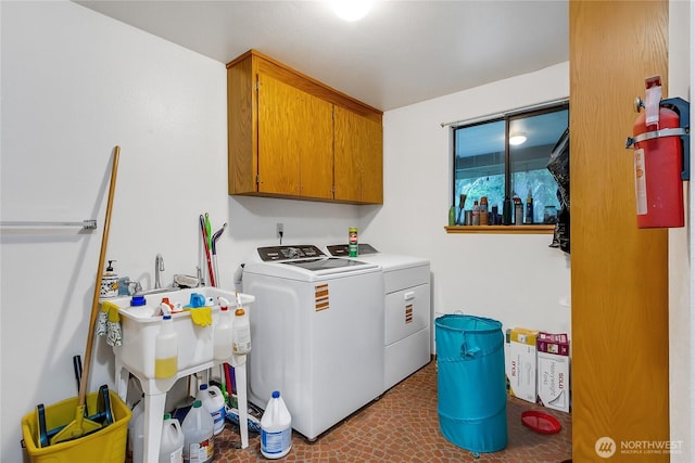 clothes washing area with washer and dryer and cabinet space