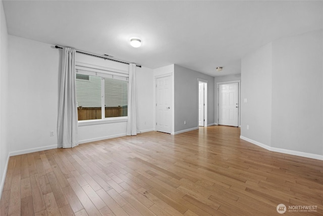 empty room with light wood-style flooring and baseboards