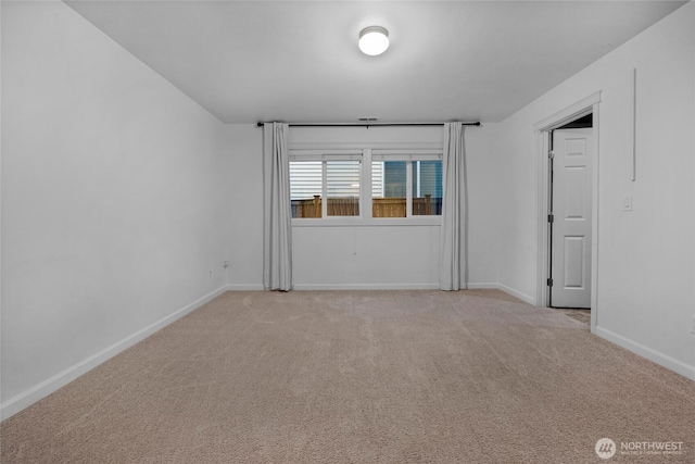 unfurnished room featuring light carpet and baseboards