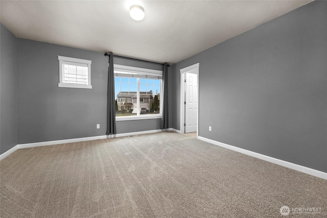 empty room featuring carpet floors and baseboards