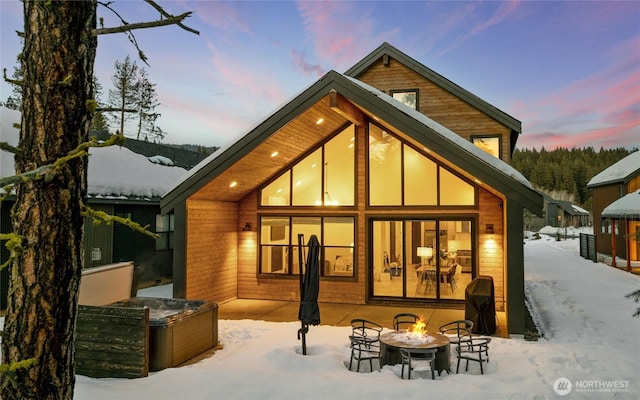 snow covered house featuring an outdoor fire pit