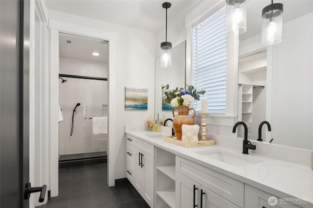 full bathroom with double vanity, tile patterned flooring, a sink, and a shower stall