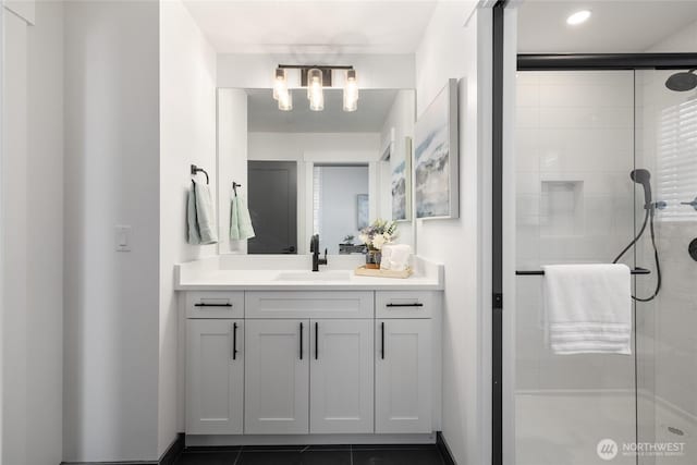 bathroom featuring a stall shower, vanity, and baseboards