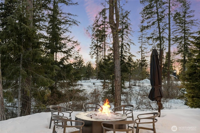 snow covered patio featuring an outdoor fire pit