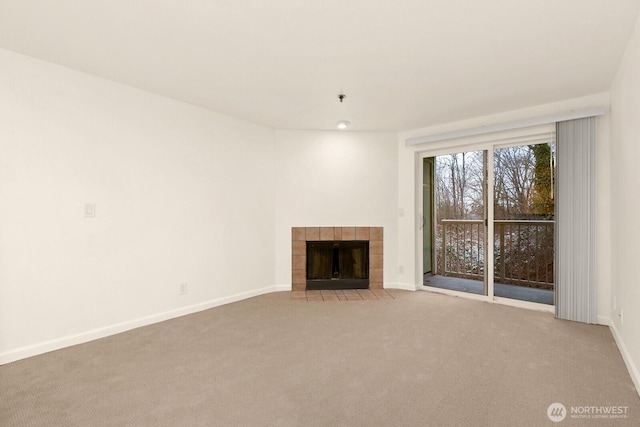 unfurnished living room featuring light carpet, a fireplace, and baseboards