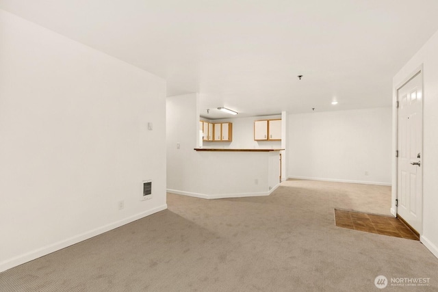 interior space with baseboards, visible vents, and light colored carpet