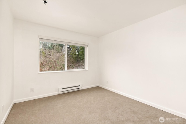 carpeted spare room with a baseboard heating unit and baseboards