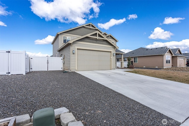 view of front of property featuring an attached garage, a gate, fence, and concrete driveway