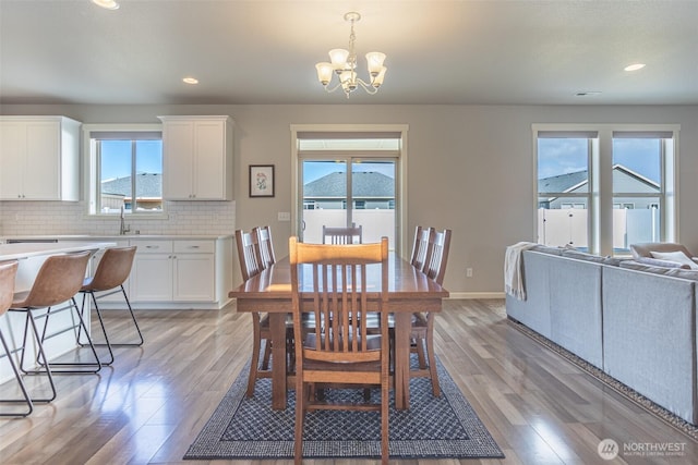 dining room featuring an inviting chandelier, light wood-style flooring, baseboards, and recessed lighting