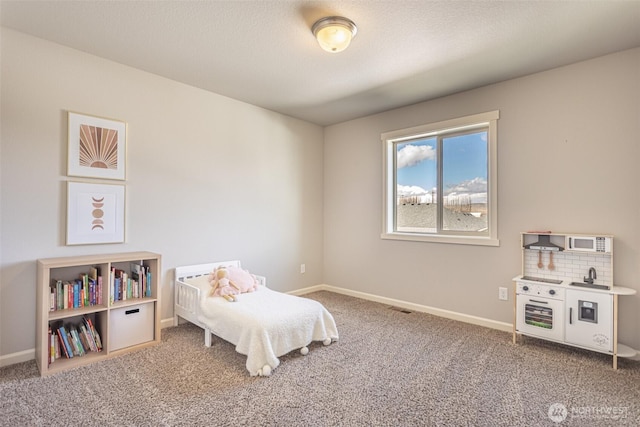 carpeted bedroom featuring a textured ceiling and baseboards