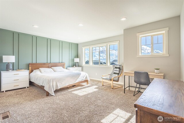 bedroom with visible vents, baseboards, carpet, a decorative wall, and recessed lighting