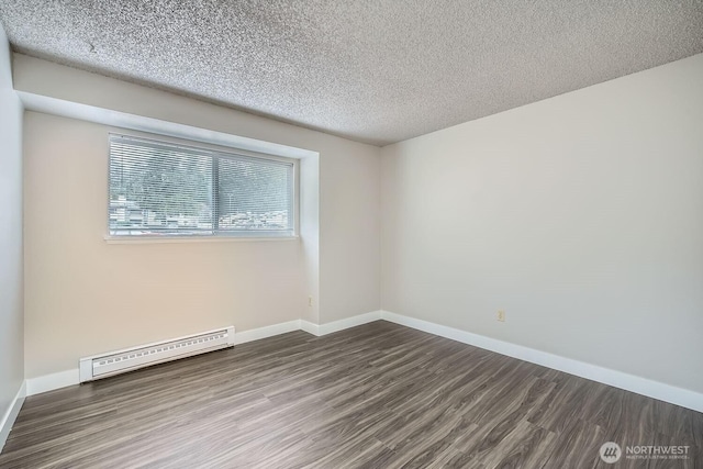 unfurnished room with a baseboard radiator, baseboards, and wood finished floors