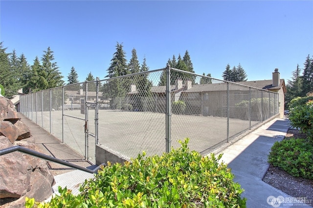 view of sport court with a gate and fence