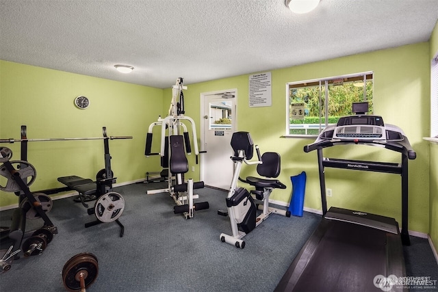 exercise area featuring baseboards and a textured ceiling