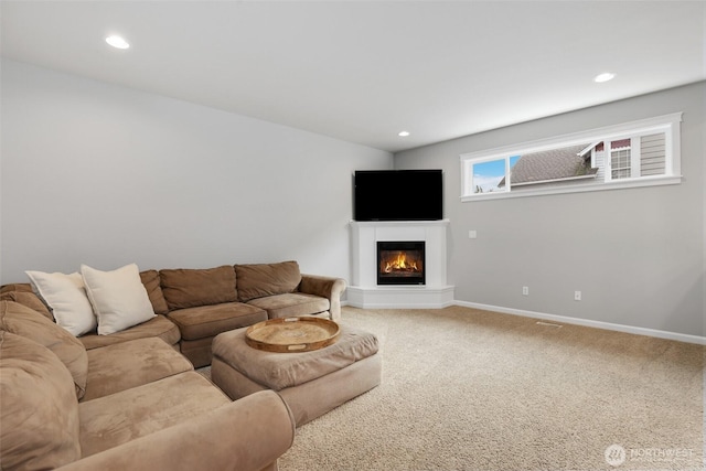 living area featuring carpet floors, recessed lighting, a glass covered fireplace, and baseboards